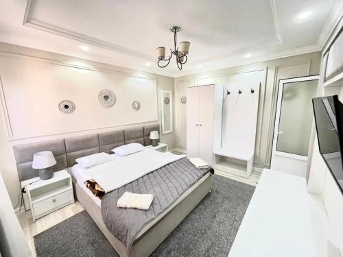 Habitación blanca con cama y espejo en ZARINA SAMARKAND, en Samarkand
