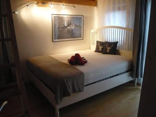 a teddy bear sitting on a bed in a bedroom at Meister-s-Ferienhaus-Tiere-herzlich-willkommen-Koenigswinkel in Karlsebene