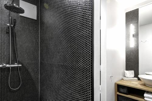 a bathroom with a black shower with a sink at Gorki Apartments in Berlin