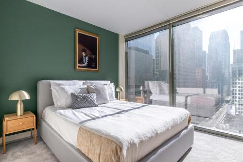 a bedroom with a bed and a large window at Loop 2BR w Gym Pool WD nr Financial District CHI-208 in Chicago