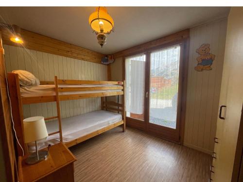 a room with two bunk beds and a window at Ty Menez 1 - Appartement sur les pistes in La Clusaz