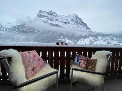 - deux chaises avec oreillers sur un balcon avec vue sur la montagne dans l'établissement Silberhorn, à Grindelwald