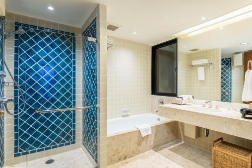 a bathroom with a tub and two sinks and a shower at Chatrium Sathon Bangkok in Bangkok