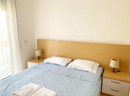 Beautiful and lovely apartment في تيرانا: غرفة نوم عليها سرير وفوط
