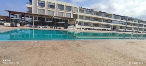 a hotel with a swimming pool in front of a building at Adan beach in Aourir
