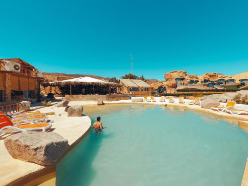 a man in a swimming pool at a resort at New Moon Island Camp in Nuweiba