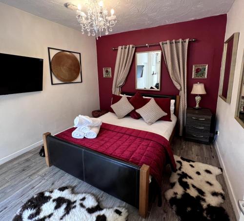 a bedroom with a large bed with red walls at Dog and castle in Wood Walton