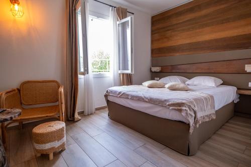 - une chambre avec un grand lit et une fenêtre dans l'établissement Hôtel & Restaurant Les Mouettes, à Belgodère