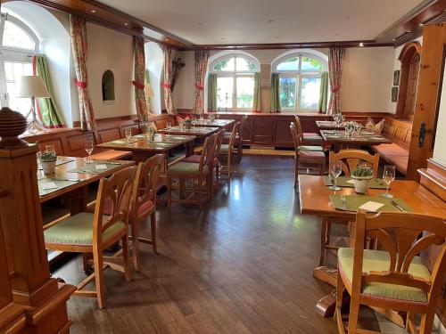 un restaurante con mesas y sillas de madera y ventanas en Hotel Jungbräu, en Abensberg