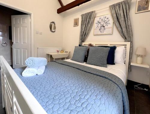 a bedroom with a large bed with blue sheets at Dog and castle in Wood Walton