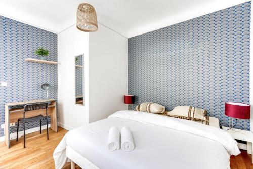 een slaapkamer met een bed en een blauwe muur bij Chic apart Paris - La defense in Courbevoie