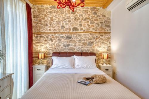 ein Schlafzimmer mit einem Bett mit einer Steinmauer in der Unterkunft Isioni Pension in Nafplio