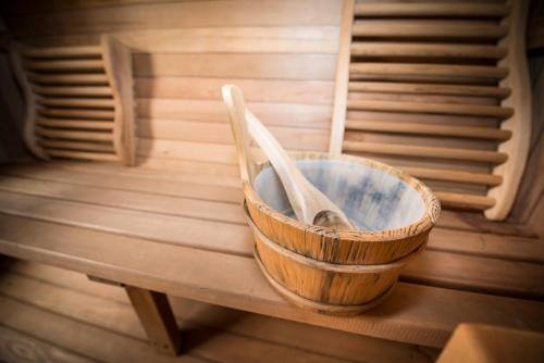 a wooden bowl with two wooden spoons sitting on a bench at Atlas in Nairn