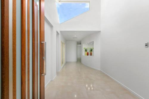 an empty hallway with white walls and a skylight at Harbour Drive Luxury in Bluewater Estate in Yorkeys Knob