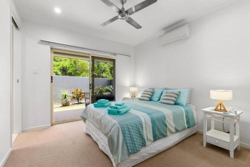 Harbour Drive Luxury in Bluewater Estate في Yorkeys Knob: غرفة نوم بيضاء بها سرير ونافذة