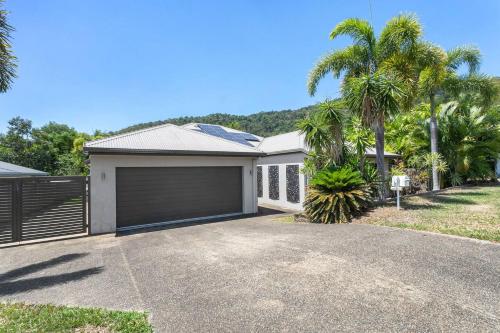 una casa con garaje y palmeras en 'Coco Tierra' Expansive Cairns Oasis with Pool, en Smithfield