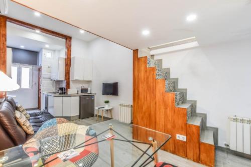 loft reformado en chueca para 4 personas في مدريد: غرفة معيشة مع أريكة ودرج