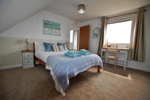 um quarto com uma cama, uma secretária e uma janela em Clover Cottage countryside retreat with sea views em Crail