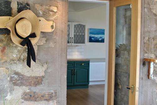 um chapéu pendurado na parede de uma cozinha em Clover Cottage countryside retreat with sea views em Crail