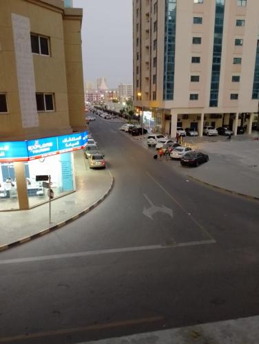 una calle vacía con coches aparcados en un estacionamiento en personel room for yourself (home) en Sharjah