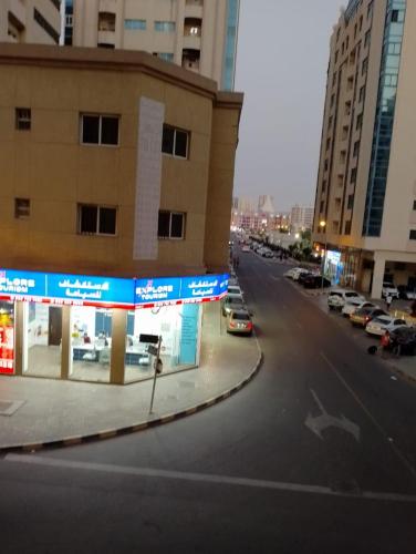 una calle de la ciudad con coches aparcados en un estacionamiento en personel room for yourself (home) en Sharjah