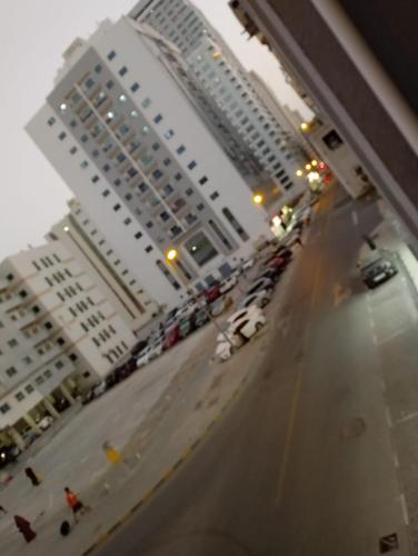 a view of a street with parked cars and buildings at personel room for yourself (home) in Sharjah