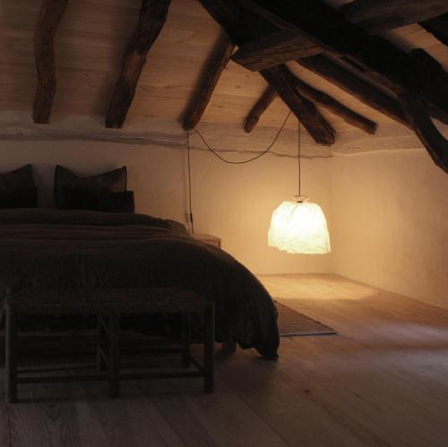 Een bed of bedden in een kamer bij VESTIGES, ancien corps de ferme rénové selon l'esprit wabi-sabi