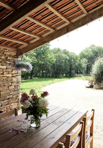 un vase de fleurs assis sur une table en bois dans l'établissement VESTIGES, ancien corps de ferme rénové selon l'esprit wabi-sabi, à Saint-Antonin
