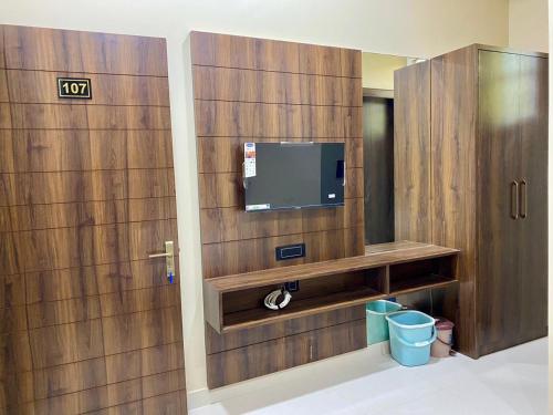 Habitación con TV y pared de madera. en Hotel Rameshwaram, Mathura, en Mathura