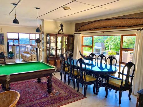 a living room with a pool table and chairs at Bushmans River Lodge in Kenton on Sea