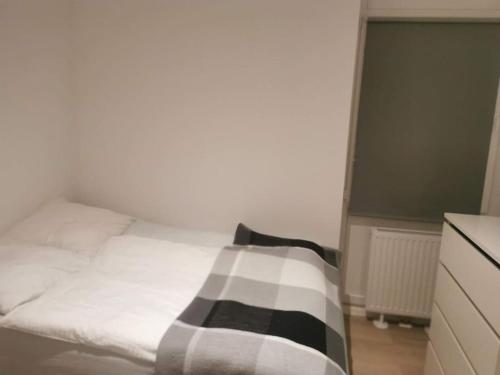 a white bed with a black and white blanket on it at Apartment in Natrup-Hagen 