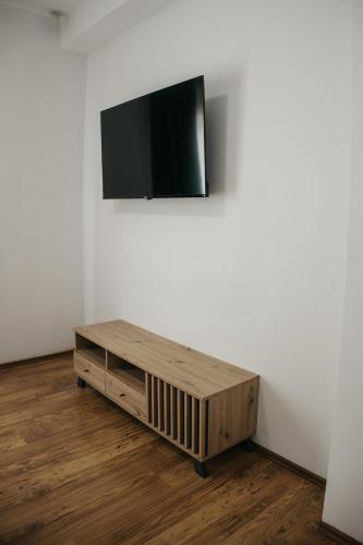 a flat screen tv on a white wall in a room at Macao Apartmani in Vinkovci