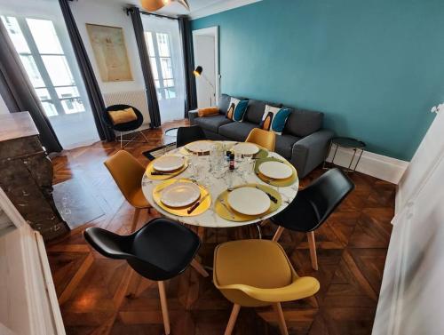 un salon avec une table et des chaises dans l'établissement Appartement cosy centre Fontainebleau, à Fontainebleau