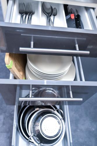 - une étagère avec des assiettes et des ustensiles dans la cuisine dans l'établissement Le Saint-Georges : Studio toulousain typique, à Toulouse