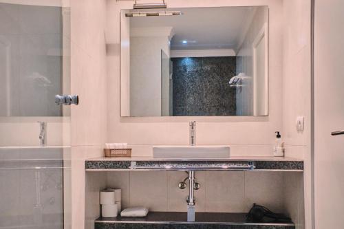 een badkamer met een wastafel en een spiegel bij Mar de Coroso by Serendipia Turismo in Ribeira