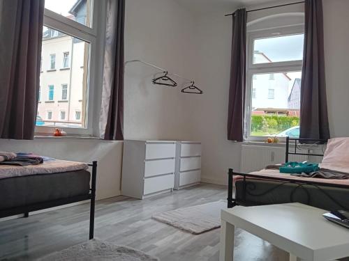 1 dormitorio con 2 camas y 2 ventanas en Stella s Monteurswohnungen en Crimmitschau