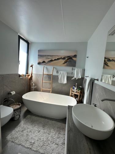 a bathroom with a large tub and two sinks at La Cà de Fer in Giubiasco