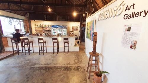 a man sitting at a bar in a restaurant at Maliblues Bed & Art Gallery in Chumphon