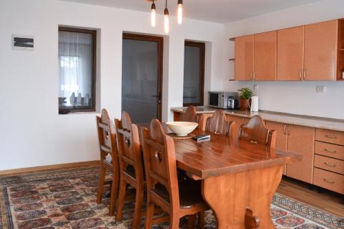 Casa Humulesti, fii vecinul lui Ion Creanga في تارجو نيمت: مطبخ مع طاولة وكراسي غرفة طعام خشبية