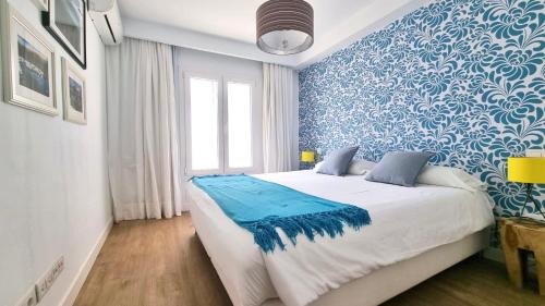 a bedroom with a large bed with blue and white wallpaper at Flower Beach suite Pool in Playa Honda