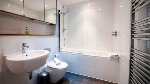 a bathroom with a sink and a toilet and a tub at Central gorgeous flat with parking in Bristol