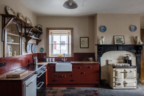 a kitchen with wooden cabinets and a stove top oven at Tullymurry House in Newry