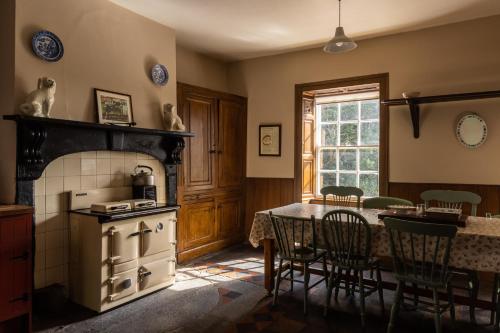 una cucina con piano cottura e tavolo con sedie di Tullymurry House a Newry