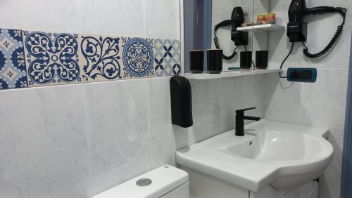 a bathroom with a sink and a phone on the wall at Lar ABEANCOS in Melide