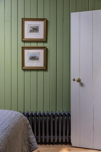a bedroom with green walls with two pictures on the wall at Merrion Mews in Dublin