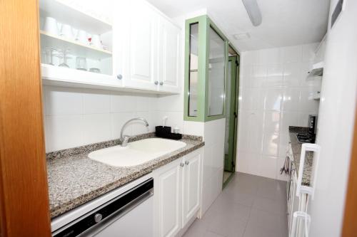 Baño blanco con lavabo y espejo en Apartamento dos habitaciones primera línea de playa en Valencia
