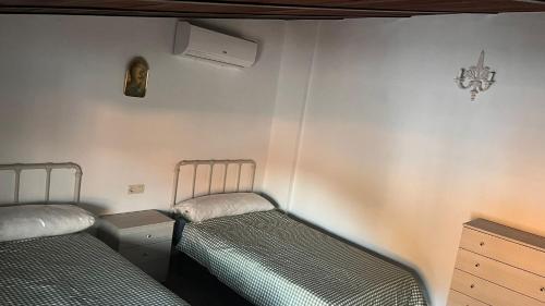 a room with two beds and a dresser in it at Cortijo Borreguero in Villanueva del Trabuco