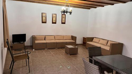 sala de estar con sofá y TV en Cortijo Borreguero en Villanueva del Trabuco