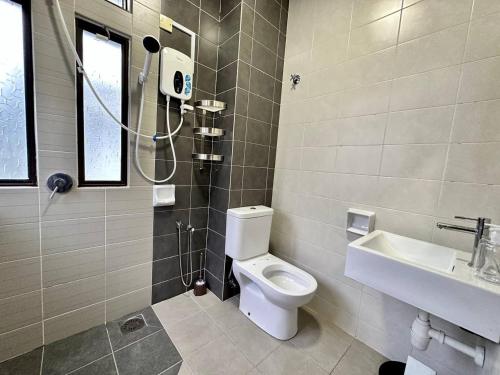 a bathroom with a toilet and a sink and a shower at Retreat Saujana rawang in Rawang