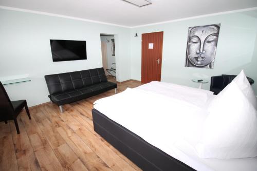 sypialnia z łóżkiem, kanapą i telewizorem w obiekcie Hotel Geromont w mieście Andernach